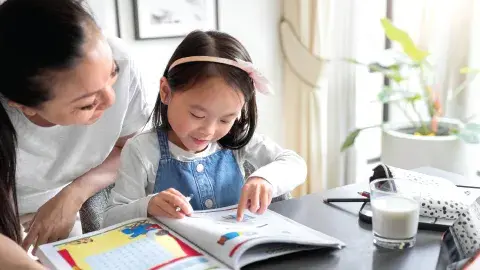 The 5-Year MFGM Advantage Follow Up Study: Little girl doing her studies with a glass of MFGM fortified milk at the table